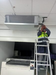 Technician installing an air conditioning unit in Kamakis, Kenya